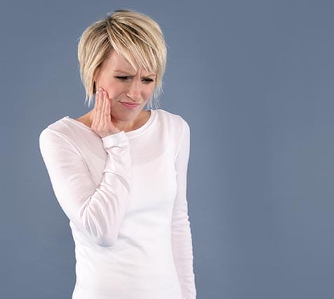 Woman with tootache holding jaw