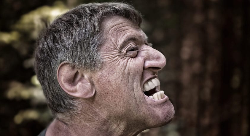 man baring his evolutionary determined fragile teeth 