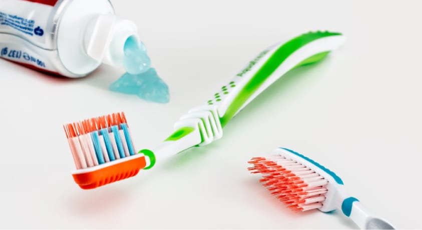 two toothbrushes and a tube of toothpaste